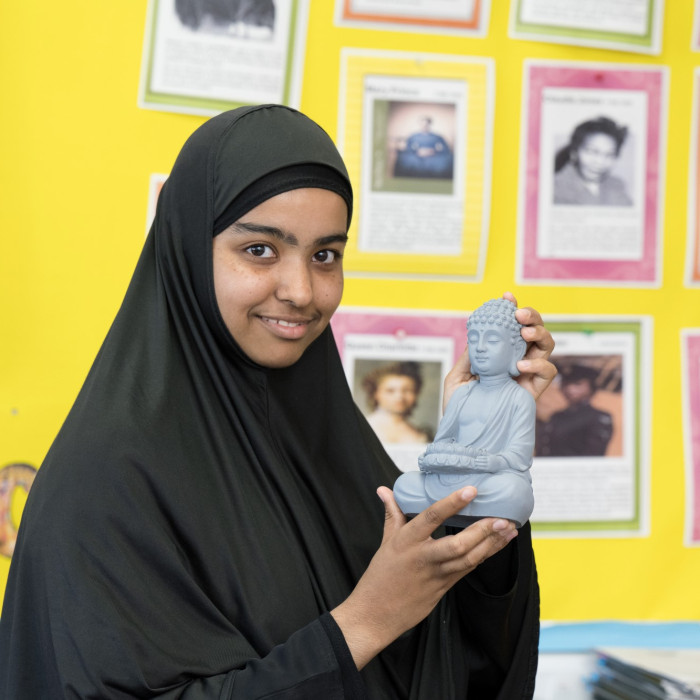 Student holding sculpture